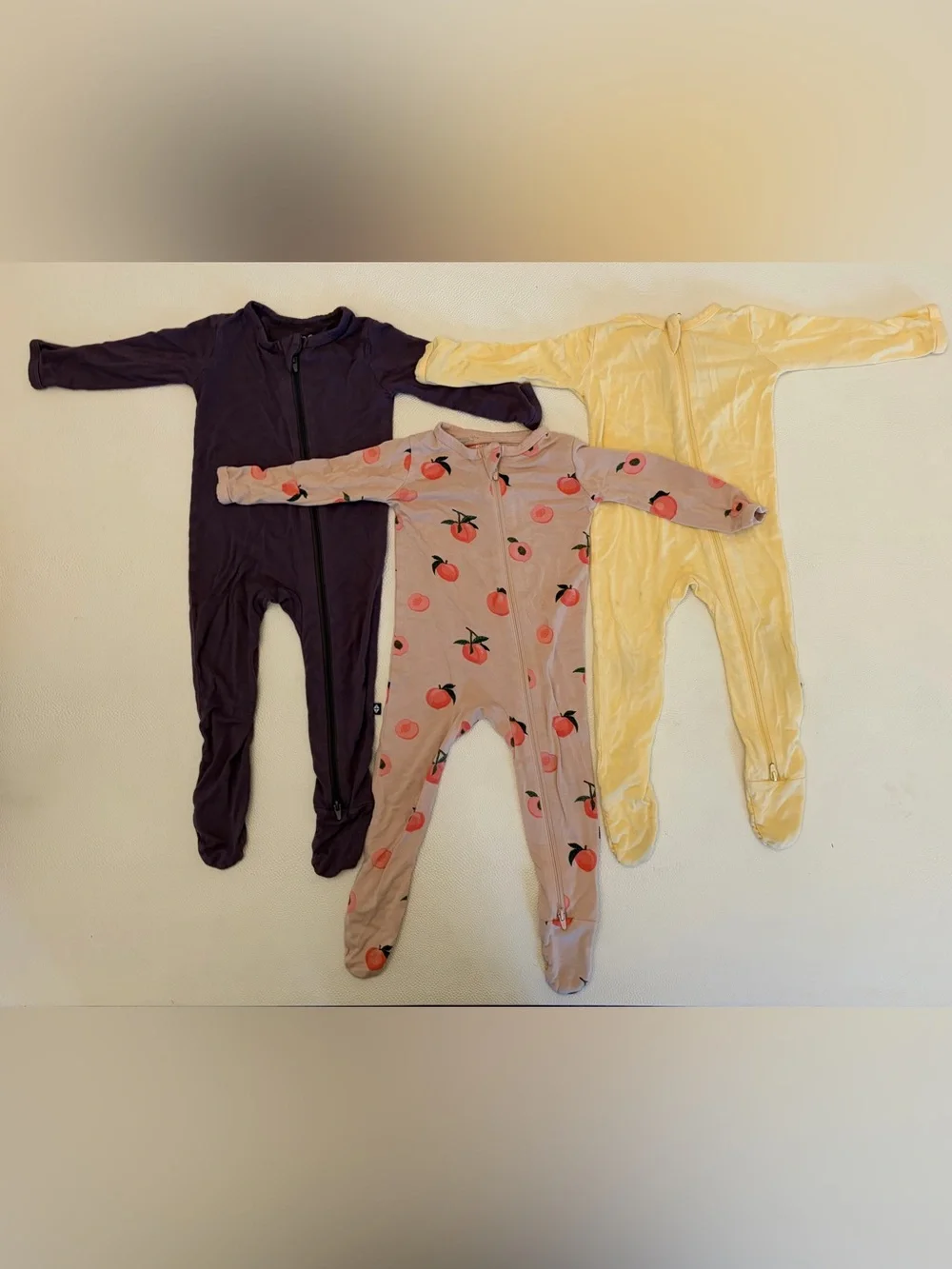 Kyte Baby Footie Zipper Pajamas TRIO. Purple, Peach Print, Yellow. 6-12mo